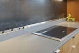 Metal back splash will develop a patina with use and includes a power strip at the base and under-cabinet illumination.