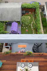 Looking down onto the Brazilian teak mid level terrace while family ziplines through the yard