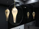 This mirrored powder room in a NYC residence provides a classy home to what appears to be several Airon Glow fixtures.