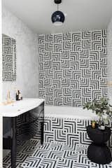 Geometric striped tiles create a texture-rich background for the tub surround and floor. 