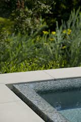 Ann Sacks glass tile forms the infinity edge of the spa.