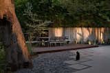 An Ipe wood deck with a custom resin and steel bench frame the dining area in a quiet corner of the garden.