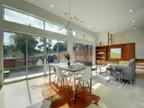 Wall of transom windows above large sliding doors, integrating interior with outdoor space.