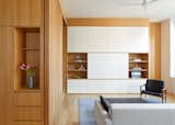 the kitchen seamlessly connects to the living room, with taller ceilings and pops of white cabinetry that play off the rich oak grain.