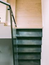 Raw blackened steel stairs and wood transition landing
