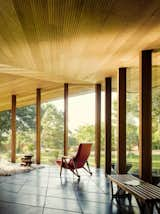 Living Room, Bench, End Tables, Concrete Floor, Ceiling Lighting, Chair, and Wood Burning Fireplace Interior looking into back space  Photos from The Telesis House