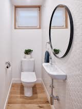 One of the great challenges in powder rooms is finding sinks that are small enough to fit into tight or narrow spaces, but that still work with the style and aesthetics of the room. Here, the all white tiling, walls, and fixtures including the sink provide a visual consistency that make it feel more spacious.