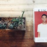 An issue of Kinfolk and some succulents sit atop a reclaimed wood table.