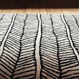 Black and white area rug creates beautiful texture and offsets the warmth of reclaimed wood flooring.