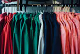 Deep green, rich blues, and light red hues adorn a rack of Topo shirts.