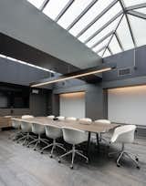 This large conference room breaks from the black and white theme to create a sea of warm neutrals flooded with natural light from above.