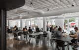 Employees eat at tables in a large entry space with plenty of windows and natural light.  Photo 9 of 12 in Step Inside Squarespace’s Minimalist Portland Office