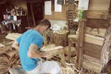A worker is seen splitting and preparing cedar planks for use in Yoshino Cedar House.