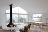 Living Room, Light Hardwood Floor, Chair, Hanging Fireplace, Pendant Lighting, and Sofa  Photo 7 of 8 in Dining by Ruci Karangutkar from A Modern Finnish Villa That Grows Out of a Seaside Cliff