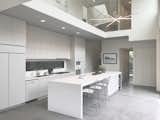 Custom linen cabinets grace the open concept kitchen. Miele range and wall oven. Custom light fixture by Edge Lighting NYC. Custom matte Corian countertops finish the large center island.