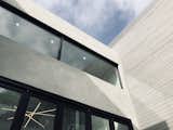 Grey stucco and stained wood siding grace the exterior elements of the home along with custom black framed windows and bi-fold doors.