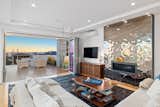 The liquid metal fireplace is a focal point in the 3rd level living room was designed to reflect light and provide a glossy contrast to the warm wood elements. Accordion doors open the stunning ocean views and lead to the expansive entertaining deck.