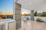 Expansive ocean view entertaining deck off the living room is laid in porcelain tile that resembles wood planks creating a clean transition throughout the home with the multiple outdoor spaces.