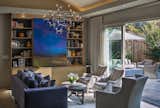 Furnishings provide for a six person conversation group with a wall of glass leading to an inviting outdoor room as large as the indoor space.  Media is hidden behind custom art doors.