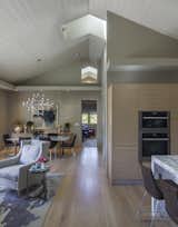 The volume of the great room with its tall ceilings and doors makes the relatively small space feel grand.  A neutral palette, light oak floors and cabinets and dramatic lighting add to the drama.