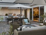 The outdoor space is furnished with comfortable lounge chairs, a large dining table and moveable umbrellas for shade. 