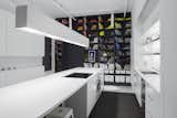 This slab island is the focal point of this minimalist kitchen, with under-counter fridge.  The bookshelf is filled with design books and art objects organized by color. The dynamic art frame is filled with an every changing collection of art provided by Electronic Objects.