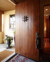 This is our Pola pivot door, customized to have a small window with wrought iron lattice . All of our standard door models come with 10 options for customization and instant pricing! Check them out at http://www.pivotdoorcompany.com/Exterior-Doors/.