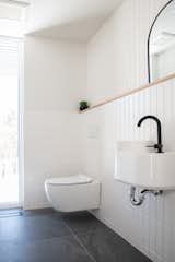 Bath Room, Wood Counter, Ceramic Tile Wall, Ceiling Lighting, Wall Mount Sink, Ceramic Tile Floor, and One Piece Toilet Powder room with "cushion metro tiles" by ITAL NORD Ceramics.  Photo 8 of 15 in The "Riverdale" house by Concept Dub