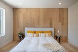 Minimalist master bedroom with white oak floors and headbed wall by MIRAGE FLOORING.