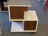 California Cliff-Hanger…on Casters! by Jamie Smith of Xylem, Inc. cabinetmakers.  Utilizing the economy of the “S” shape, this creative cat house offers three levels – internal and external – rendered in white and wood-grain laminates. Today, a real California Cliffhanger might feature a “green,” or vegetated roof. This roof is covered in carpeting, however, that inspires hours of scratching. And napping. And the casters let the owner’s human move it around to find a sun spot, offer a view out a window, tuck into a dark corner if strangers come in the house…  