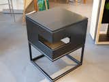 A Cat’s Loft by Will Alphin, founder and principal of REdesign.build, and his talented team. The sleek black cube features the smooth, satin finish of a fine piece of furniture. The cube sits on a metal frame base, allowing the piece to do double duty as a cat’s modern loft and a side table. The opening  lets the resident peek out from this elegant hiding place. A removable lid allows humans to locate their feline friend quickly, vacuum up the accumulated cat hair, and get rid of the occasional fur ball with ease.