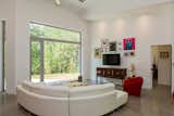 A wall of aluminum-framed glazing provides a full view of the forest beyond the homeowners' property,