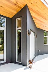 At the front door, a slim side window lets sunlight spill into the house behind the steel door. 
