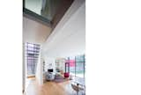 Hallway and Medium Hardwood Floor Double-height space serves as a transition between old and new.  Photo 7 of 12 in Hillcrest House Addition: An Innovative Approach to Old + New by Kim Weiss