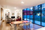 View from the new kitchen to the fireplace that anchors the space at the opposite end. The glass wall provides views of the backyard and the architecturally diverse neighborhood.