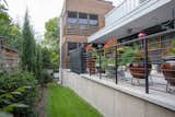 The patio along one side of the house, concluding at the stacked screened porches.