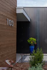 Natural cedar is a warm counterpoint to the dramatic steel wall at the entrance.