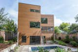 The rear elevation facing the pool area. Cedar fencing traces the property lines on both sides.