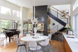 Beyond the dining space, an open staircase provides vertical circulation.