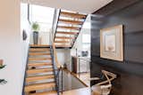The black steel and white oak on the staircase echo the white oak flooring and steel wall nearby.