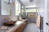 The master bath features Shadow Onyx for the vanity countertop, the shower bench, and the shower back panel. The floor tile, vanity wall and shower are Resing Berlin Grey tile. The twin sinks are custom copper.