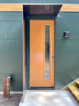 Concrete Siding Material Front door with metal protection from rain. The emerald-green exterior suggests the "jewel box" interior.  Photo 5 of 16 in A Jewel Box for a Special Ops Soldier by Kim Weiss