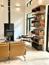 "Floating" bookshelves designed by Arielle Condoret Schechter, AIA, and a freestanding fire place anchor the living space.