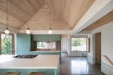 Kitchen, Engineered Quartz Counter, Concrete Floor, Wood Backsplashe, Pendant Lighting, Cooktops, Ceiling Lighting, Colorful Cabinet, Refrigerator, and Undermount Sink A view of the kitchen with a window to the screened porch; looking northwest  alex’s Saves from Chalet Papillon