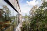 Exterior, Metal Roof Material, Glass Siding Material, Cabin Building Type, Wood Siding Material, and Gable RoofLine An exterior view of the structural silicone glazing in the dining and living room; view looking southeast  Photo 16 of 59 in Chalet Papillon by RobitailleCurtis