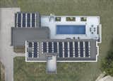 Exterior, House Building Type, Stucco Siding Material, and Flat RoofLine Aerial photo showing solar panels which generate enough electricity for the house and two electric cars and the "no mow" Nebraska prairie grass lawn.  Photo 1 of 12 in Burnett Solar House by Steven Ginn