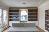 Custom wood veneer and white lacquer book shelf built around window.