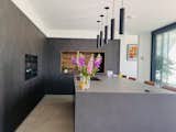 Kitchen, Quartzite Counter, Porcelain Tile Floor, Wall Oven, Colorful Cabinet, and Pendant Lighting  Photo 8 of 15 in THE DANCING HOSUE by Glen Thomas Architecture Ltd 