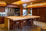 The renovated kitchen honors architectural precedentsin the house, including lighting coves, crescentdrawer pulls, and match-grained cabinetry doorsthat roll along the same hardware used in 1947. Theclerestory directs light onto the maple island, whoseproportions and structure pay homage to the diningroom’s original table. Even the terrazzo recalls thefeeling of the first flooring material—asbestos tile—which was abated for safety.&nbsp;