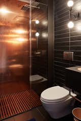 The bathroom features 2 copper walls, paper composite tiles floor to ceiling and an Ipe shower mat